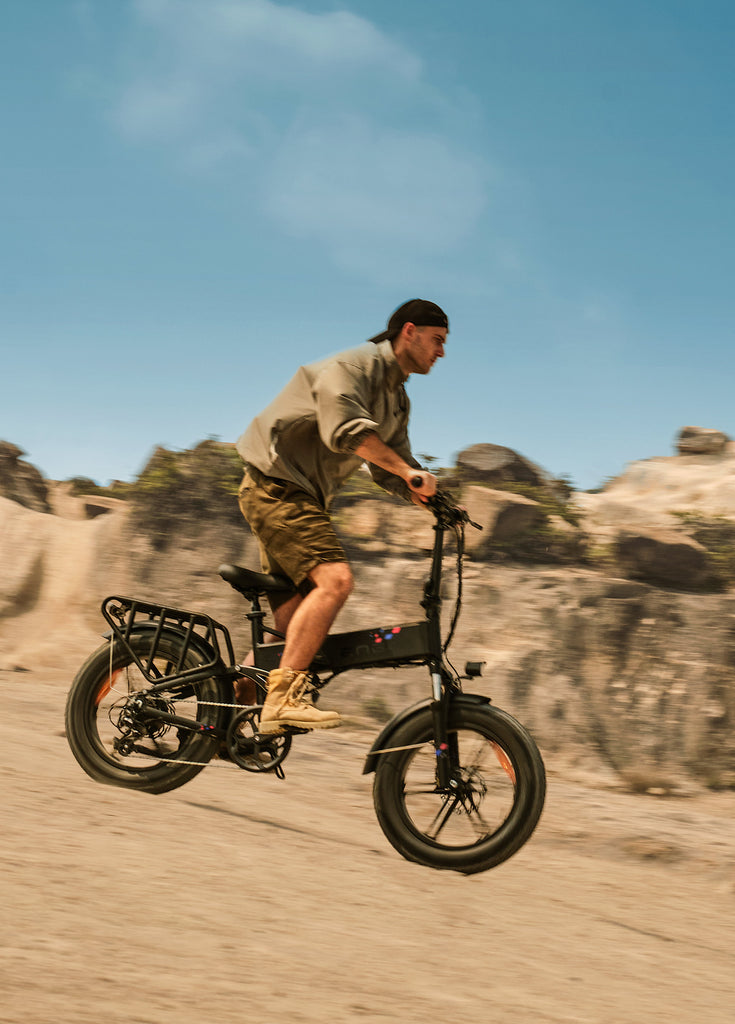 a man riding an engwe engine pro on the sand